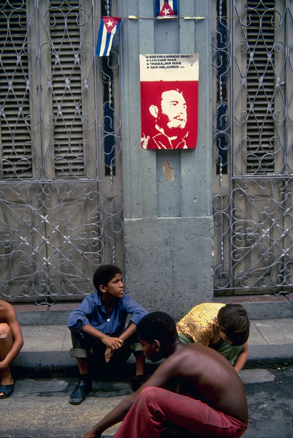 1977, spielende Kinder vor einem Fidel-Plakat.