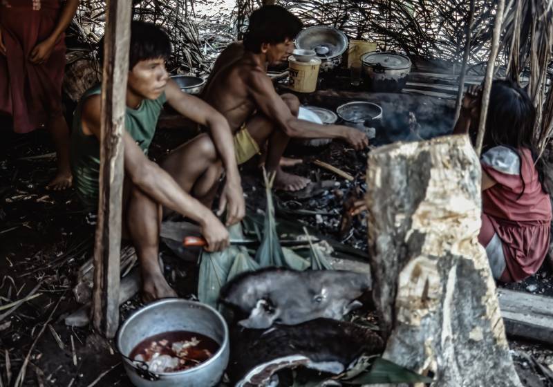 1989, Huaorani-Familie beim Zubereiten eines Tapirs für das Mittagessen.