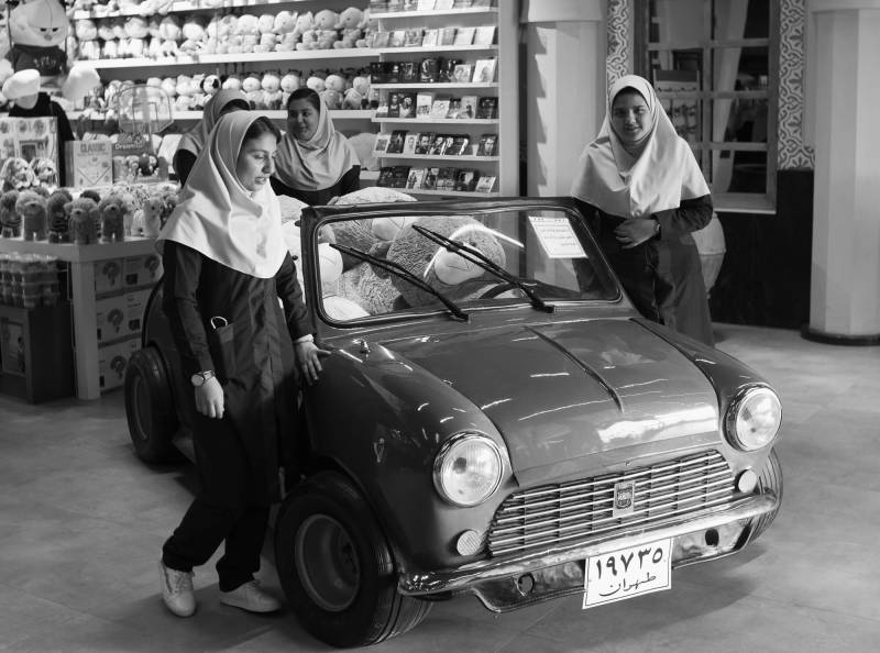 2019, iranische Studentinnen bestaunen einen Mini-Cooper.