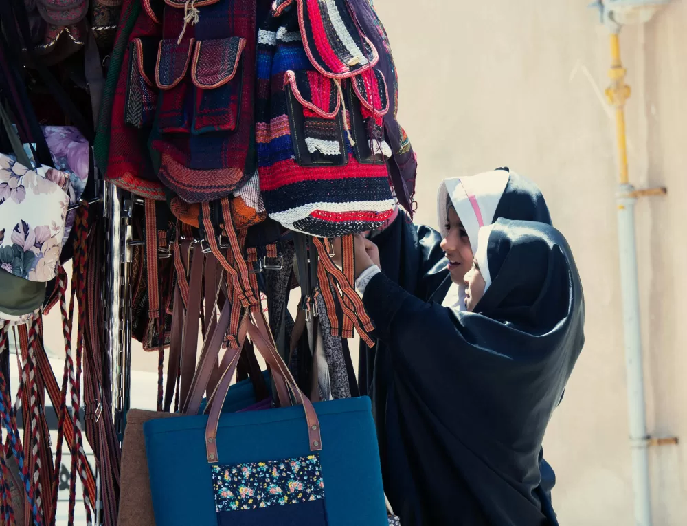 2019, Kashan, Kinder interessieren sich für Taschen auf dem Markt.