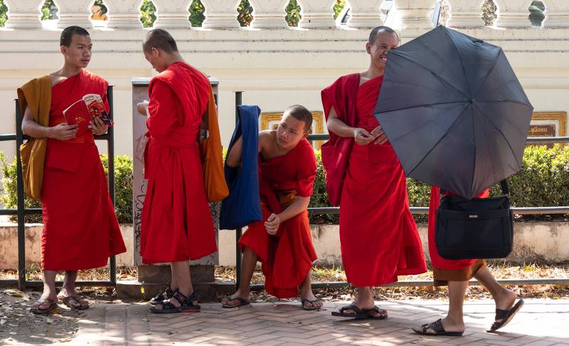 2019, Luang Prabang, Bettelmönche an der Bushaltestelle.