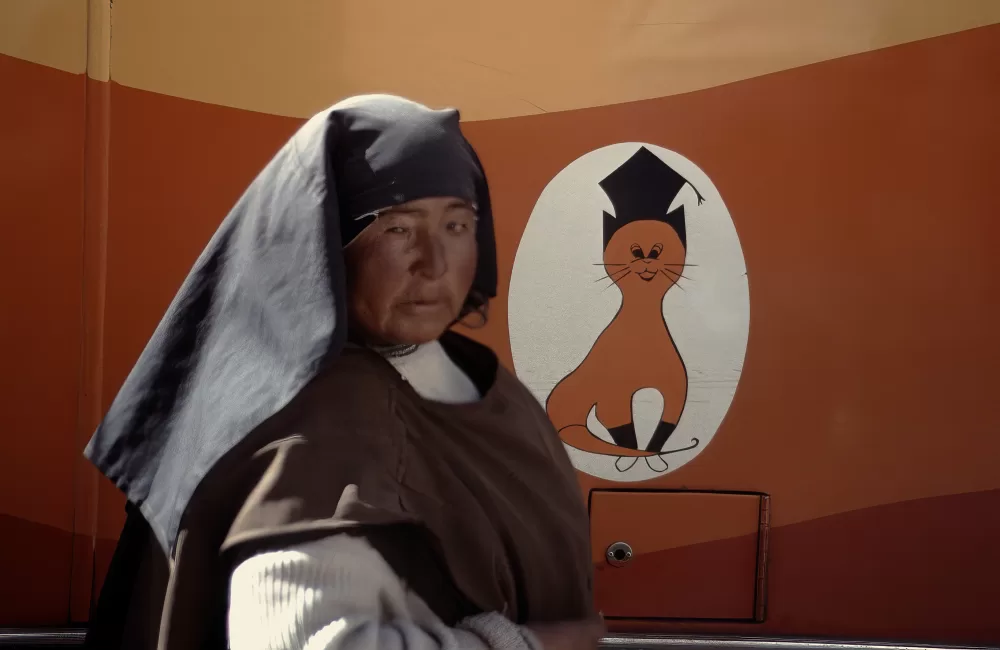 1985, Cusco, Nonne vor einem Logo einer Busfirma.