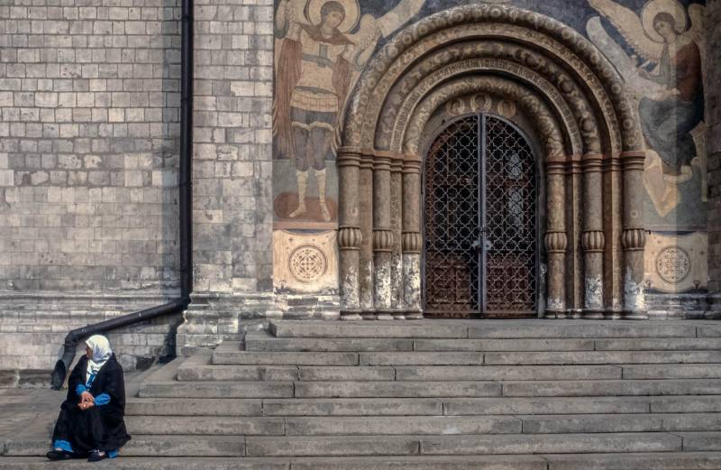 Frau vor orthodoxer Kirche.